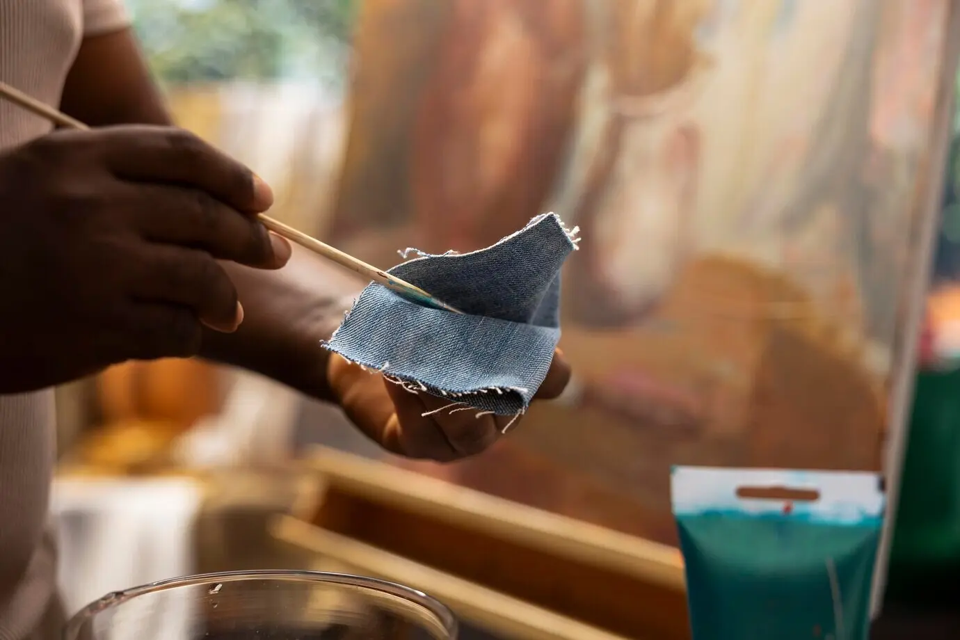 Ein geschickter Maler wischt den Pinsel an Jeansstoff ab, um die Farben zu säubern.